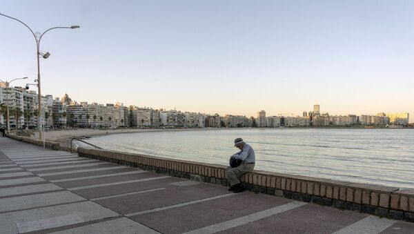 Homem sentando na praia de Pocitos, no Uruguai - Sputnik Brasil