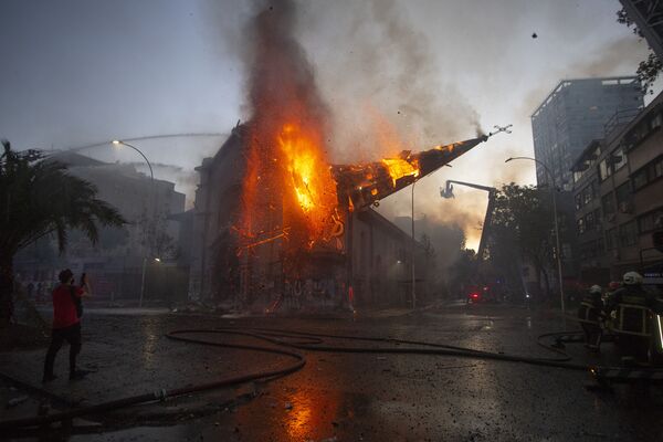 A cúpula da igreja de Assunção cai em chamas após ser incendiada por manifestantes na comemoração do primeiro aniversário da insurreição social no Chile
 - Sputnik Brasil