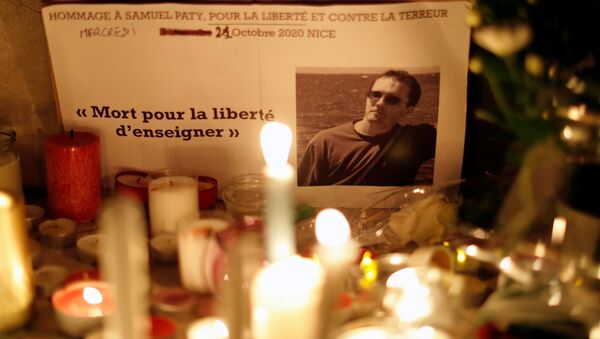 Morto pela liberdade de ensinar, escrito à esquerda da fotografia do professor francês assassinado, colocada entre velas em tributo nacional - Sputnik Brasil