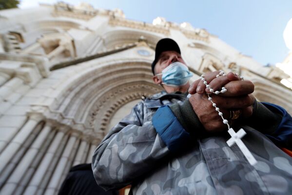 Homem reza em frente à Basílica de Notre-Dame para prestar homenagem às vítimas do ataque mortal com faca em Nice, França, 30 de outubro de 2020 - Sputnik Brasil