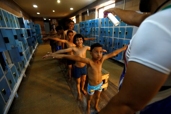 Crianças iraquianas formam fila para receber desinfecção antes de usarem uma piscina na cidade de Kerbala, Iraque - Sputnik Brasil