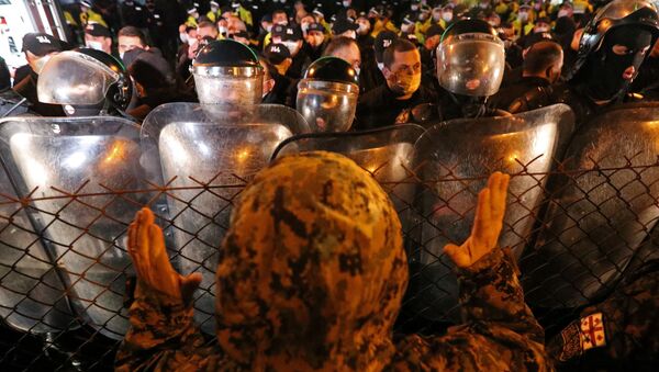 Homem gesticula para policiais em protesto em Tbilisi, na Geórgia - Sputnik Brasil