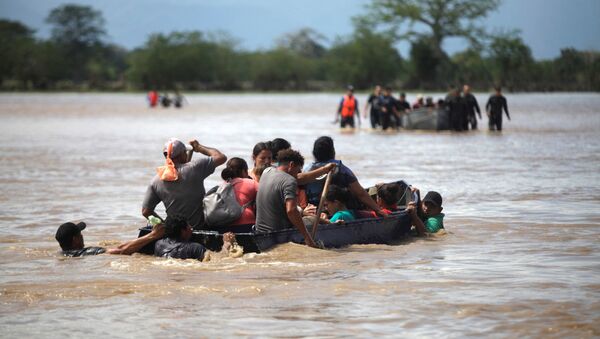 Pessoas afetadas pela enchente pegam um barco para atravessar uma rua após a passagem da Tempestade Eta, em La Lima, Honduras, 7 de novembro de 2020. - Sputnik Brasil