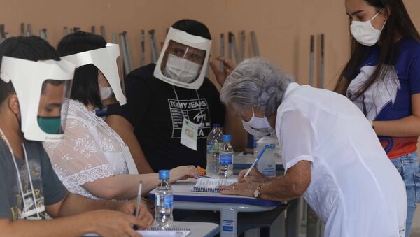 Perto da capital cearense, Fortaleza, uma mulher idosa, usando máscara, vota acompanhada nas eleições municipais de 2020 na cidade de Russas, em meio à pandemia da COVID-19, em 15 de novembro de 2020 - Sputnik Brasil