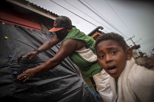 Homem protege janelas de casa antes da chegada do furacão Iota em Bilwi, Puerto Cabezas, Nicarágua, 15 de novembro 2020. - Sputnik Brasil