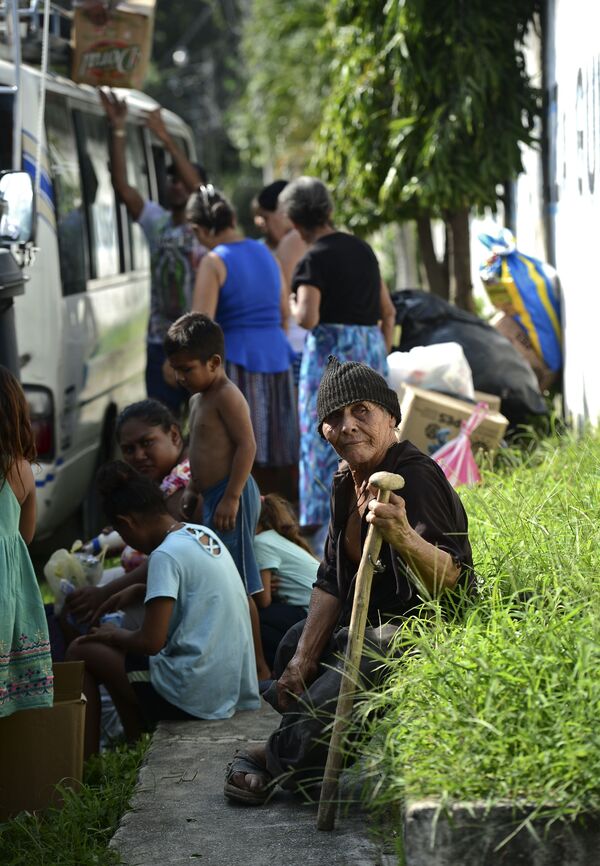 Pessoas esperam para ser evacuadas de campos de banana a bordo de um miniônibus no município de La Lima, Honduras. - Sputnik Brasil