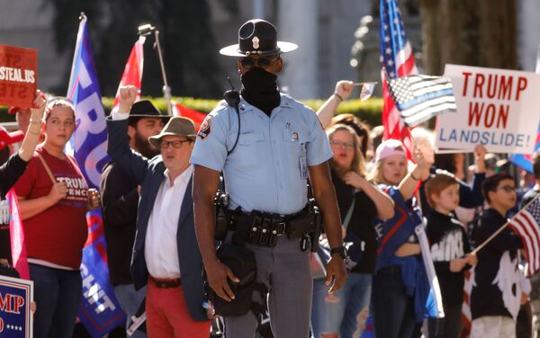 Policial acompanha manifestação de apoiadores de Trump em Atlanta, Geórgia, contra resultado das eleições presidenciais dos EUA - Sputnik Brasil