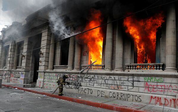 Bombeiro tenta apagar as chamas do edifício do Congresso Nacional na Guatemala - Sputnik Brasil
