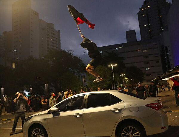 Manifestante salta por cima do carro durante uma marcha em São Paulo no Dia da Consciência Negra em protesto contra a morte de João Alberto Silveira Freitas, homem negro espancado até ser morto em um supermercado em Porto Alegre, 20 de novembro, 2020. - Sputnik Brasil