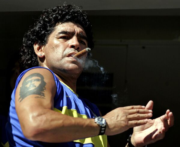 Diego Maradona fuma um charuto enquanto assiste ao início da partida entre Boca Juniors e San Lorenzo no estádio de La Bombonera, em Buenos Aires, em 19 de fevereiro de 2006 - Sputnik Brasil