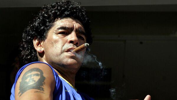 Diego Maradona fuma um charuto enquanto assiste ao início da partida entre Boca Juniors e San Lorenzo no estádio de La Bombonera, em Buenos Aires, em 19 de fevereiro de 2006 - Sputnik Brasil