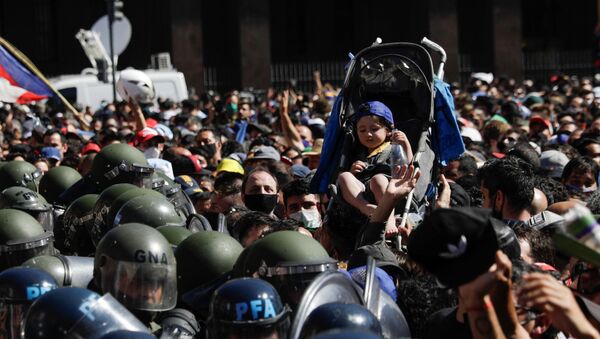 Em Buenos Aires, uma criança em um carrinho de bebê é erguida acima da multidão que acompanha o velório do ex-jogador argentino Diego Armando Maradona, na Casa Rosada, em 26 de novembro de 2020 - Sputnik Brasil