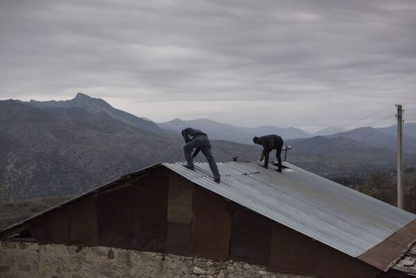 Homens desmontam telhado de casa no povoado de Karegah, Azerbaijão - Sputnik Brasil