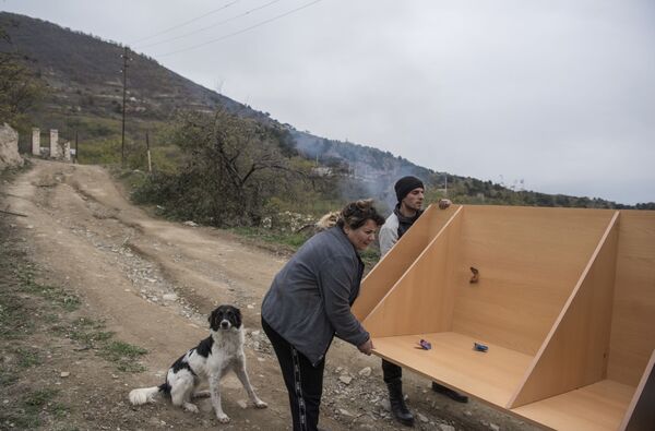 Moradores locais carregam mobílias no carro antes de partir do povoado de Karegah, Azerbaijão. - Sputnik Brasil