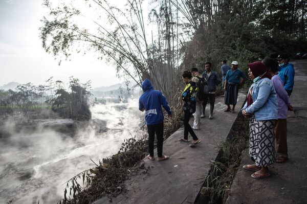 Moradores observam o fluxo quente ocasionado pelo rio de lava em Lumajang, província da ilha de Java, em 2 de dezembro 2020, após erupção do vulcão Monte Semeru - Sputnik Brasil