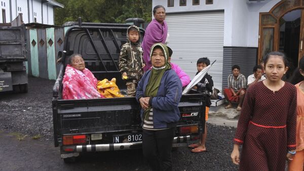 Mulheres indonésias sentam-se na parte de trás de um caminhão, se preparando para evacuação de suas casas, após erupção do Monte Semeru em Lumajang, província da ilha de Java, Indonésia, no dia 1º de dezembro 2020 - Sputnik Brasil