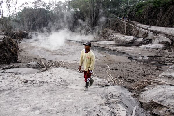 Homem anda por caminho coberto com cinzas vulcânicas após erupção do Monte Semeru em Lumajang, província da ilha de Java, Indonésia, em 2 de dezembro 2020 - Sputnik Brasil