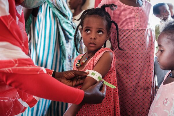 Menina refugiada de quatro anos da Etiópia durante exame em centro de trânsito em Gedaref, Sudão
 - Sputnik Brasil