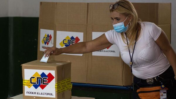 Em Caracas, na Venezuela, uma mulher deposita seu voto durante as preparações para eleições parlamentares venezuelanas, em 15 de novembro de 2020 - Sputnik Brasil