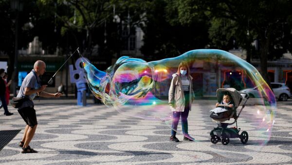Artista de rua entretendo criança com bolhas de sabão na Praça D. Pedro IV em Lisboa, 31 de outubro de 2020 (foto de arquivo) - Sputnik Brasil