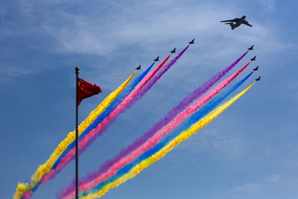 Em Pequim, caças J-10 deixam rastros coloridos diante de bandeira da China durante comemorações do 70º aniversário da derrota do Japão na Segunda Guerra Mundial - Sputnik Brasil