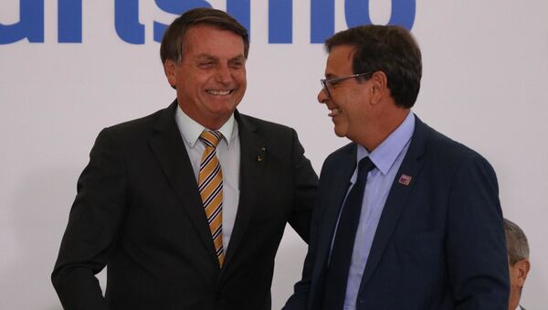 Em Brasília, o presidente brasileiro Jair Bolsonaro e o presidente da Embratur, Gilson Machado, se cumprimentam durante Cerimônia de Lançamento da Retomada do Turismo, no Palácio do Planalto, em 10 de novembro de 2020 - Sputnik Brasil