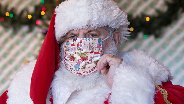Homem vestido de Papai Noel usa máscara protetora em centro comercial em Nova York, EUA, 6 de dezembro de 2020  - Sputnik Brasil