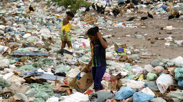 Realidade brasileira: mãe de 37 anos procura num lixão de Tracuateua, nordeste do Pará, algo que lhe sirva para vestir, calçar, e, às vezes, alimentar-se. - Sputnik Brasil