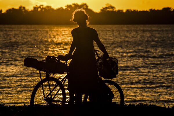 Ciclista admirando o pôr do sol no lago Guaiba, Porto Alegre, 8 de dezembro de 2020 - Sputnik Brasil