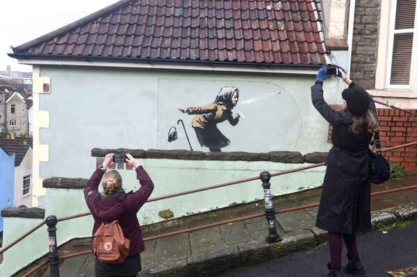 Pessoas tiram fotos da nova obra de arte de rua de Banksy, intitulada Aachoo!!, em Totterdown, Bristol, Reino Unido, 11 de dezembro de 2020 - Sputnik Brasil