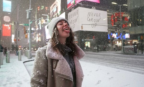 Turista parada debaixo da neve em Times Square, Nova York, EUA, enquanto a tempestade Gail atinge a costa leste, 16 de dezembro de 2020 - Sputnik Brasil