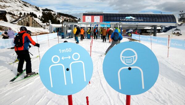 Em Les Crosets, na Suíça, esquiadores passam por placas que sinalizam medidas de proteção contra a COVID-19, em 19 de dezembro de 2020 - Sputnik Brasil