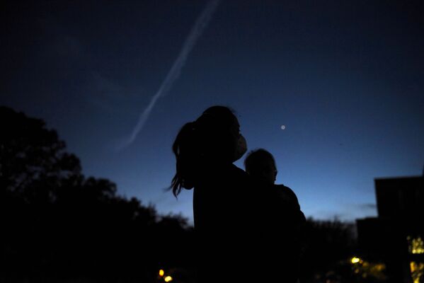 Mulher segura seu filho enquanto observam Saturno e Júpiter durante a conjunção entre os dois planetas, Texas, EUA, 21 de dezembro de 2020 - Sputnik Brasil