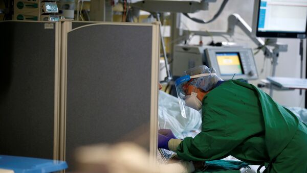 Médico de macacão de proteção atende a paciente com COVID-19 na unidade de terapia intensiva do hospital universitário em Aachen, Alemanha, 21 de dezembro de 2020 - Sputnik Brasil