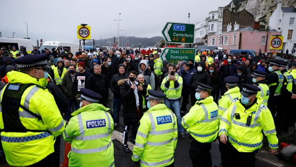 Motoristas junto de policiais bloqueando a saída no Porto de Dover, Reino Unido, durante a proibição de viagens do Reino Unido devido a uma nova estirpe do coronavírus, em 23 de dezembro de 2020 - Sputnik Brasil