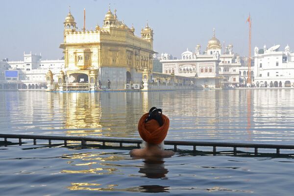 Devoto sikh indiano se banha no sagrado sarovar (reservatório de água) do Templo de Ouro no Dia do Martírio do guru Tegh Bahadur, em Amritsar, Índia, 19 de dezembro de 2020 - Sputnik Brasil