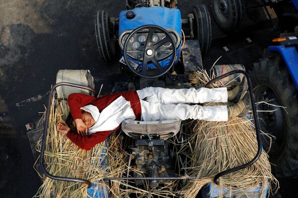 Filho de fazendeiro dorme em trator durante o protesto contra novas leias agrícolas, na fronteira entre Deli e Uttar Pradesh - Sputnik Brasil