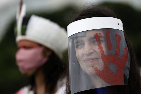 Mulher usando escudo facial com impressão de mão vermelha, imitando sangue, protesta contra desempenho do presidente da República Jair Bolsonaro em meio à pandemia de COVID-19, Brasília, 23 de dezembro de 2020 - Sputnik Brasil