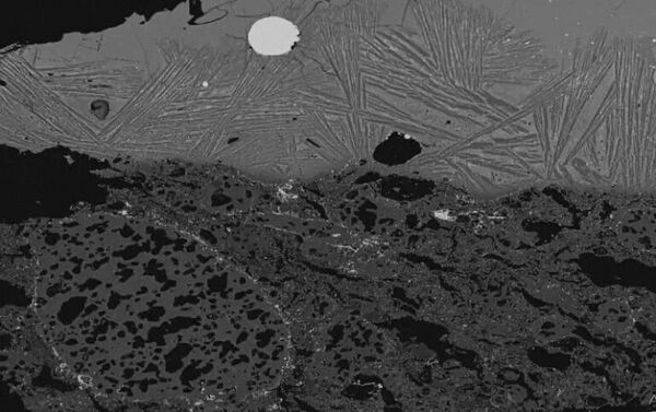 Imagem de microscópio eletrônico mostrando escória dentro de um cadinho, com uma mancha prateada visível no centro superior (primeira evidência conhecida da mistura de cromo no aço pelos antigos persas no sec. XI) 
 - Sputnik Brasil