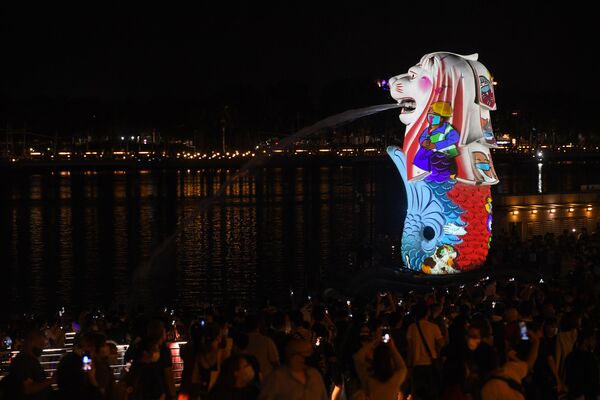 Pessoas assistem a iluminação especial da estátua do Merlion como parte das celebrações da véspera de Ano Novo em Cingapura, em 31 de dezembro de 2020 - Sputnik Brasil