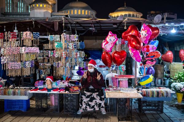 Vendedora de rua faz o V de vitória na praça Taksim, Istambul, Turquia, durante as celebrações do Réveillon, em 31 de dezembro de 2020 - Sputnik Brasil
