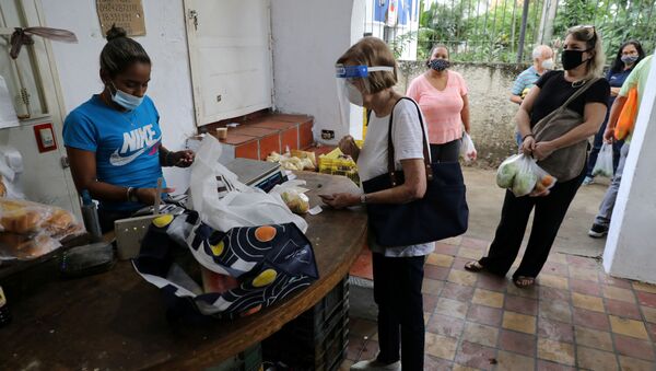 Pessoas usando máscaras contra coronavírus fazem compra em mercado aberto em Caracas, na Venezuela - Sputnik Brasil