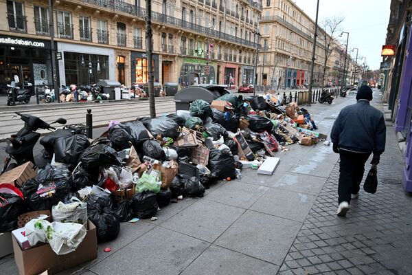 Pedestre caminha em rua cheia de lixo, devido à greve da empresa recolhedora de lixo de Marselha, França, 28 de dezembro de 2020 - Sputnik Brasil