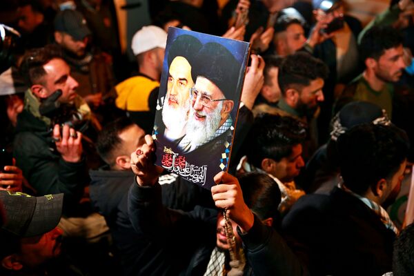Membros das Forças de Mobilização Popular xiitas do Iraque cantam slogans contra os EUA no Aeroporto Internacional de Bagdá, Iraque, ao passo que homenageiam o major-general iraniano Qassem Soleimani - Sputnik Brasil
