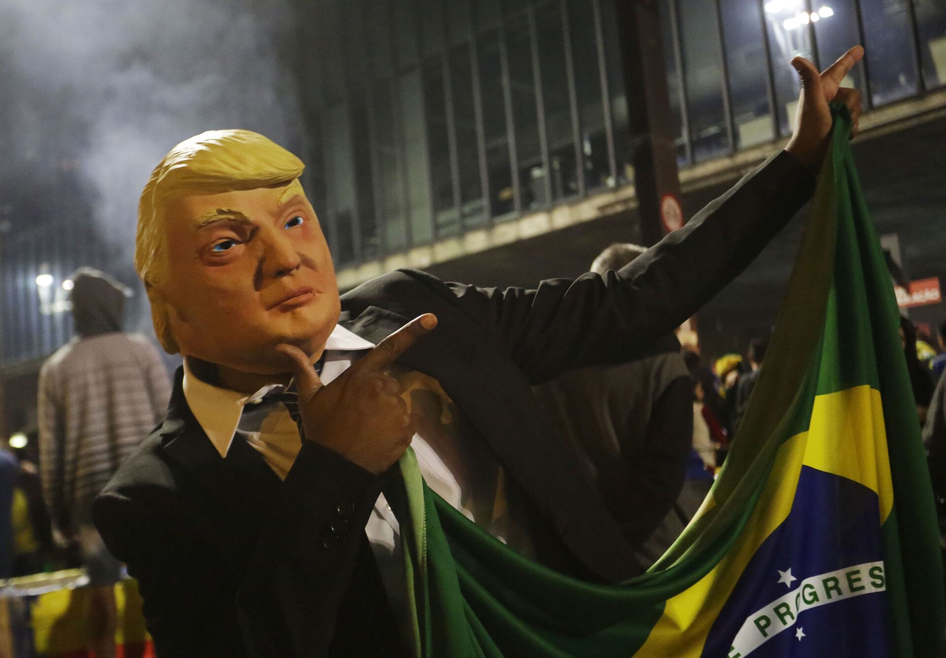 Apoiador do candidato presidencial Jair Bolsonaro usa uma máscara representando o presidente dos Estados Unidos Donald Trump durante as comemorações na Avenida Paulista, em São Paulo - Sputnik Brasil, 1920, 25.11.2022