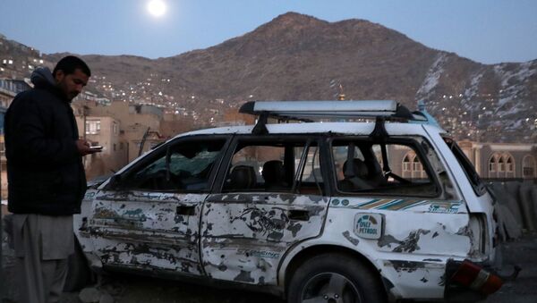 Um afegão inspeciona carro danificado após a explosão de uma bomba em Cabul, Afeganistão - Sputnik Brasil