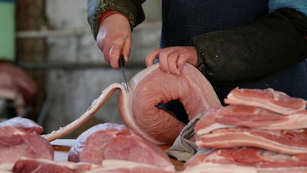 Comerciante corta carne de porco em mercado de Pequim, na China - Sputnik Brasil