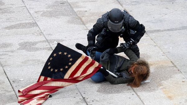 Policial imobiliza manifestante favorável a Donald Trump na frente da sede do Congresso dos EUA, Washington, 6 de janeiro de 2021 - Sputnik Brasil