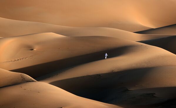 Jovem passa pelas dunas de areia no deserto de Liwa, Emirados Árabes Unidos, 9 de janeiro de 2021 - Sputnik Brasil