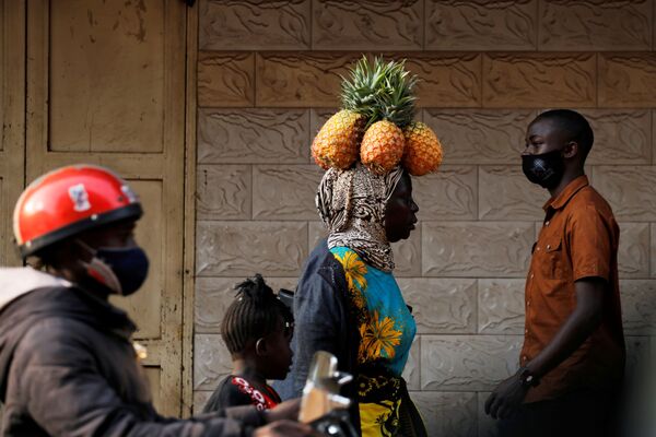 Mulher leva abacaxis na cabeça em rua de Campala, Uganda, 12 de janeiro de 2021 - Sputnik Brasil